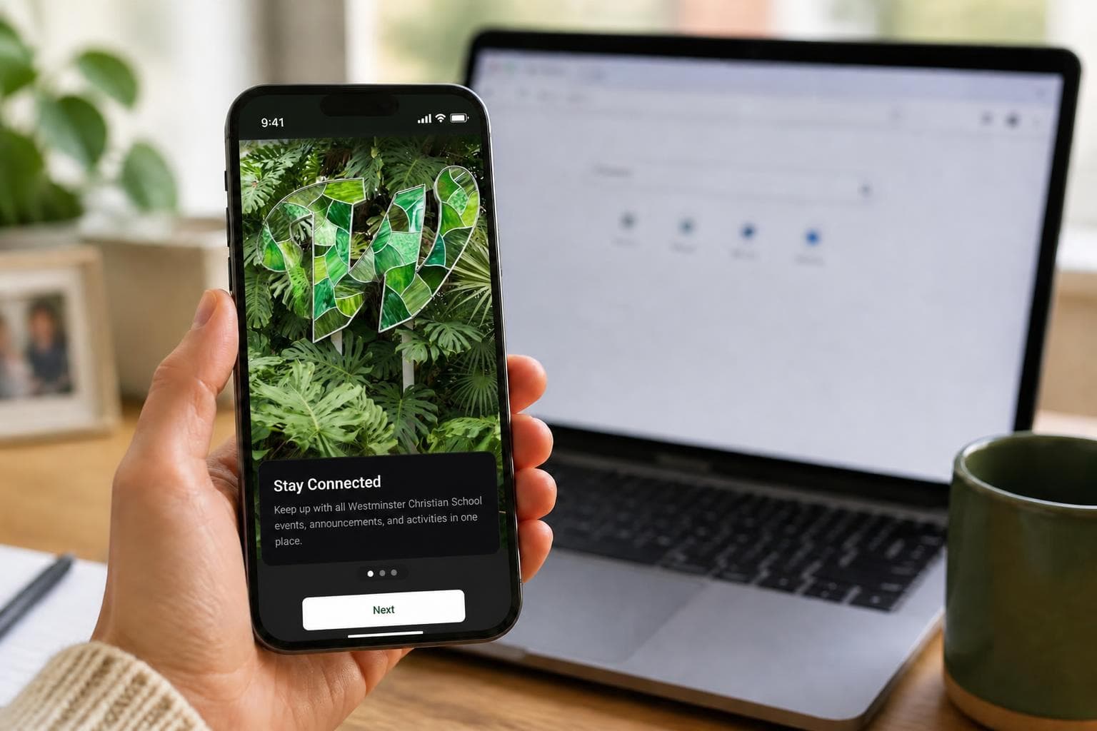 A hand holding a phone showing the Westminster Christian School app welcome screen